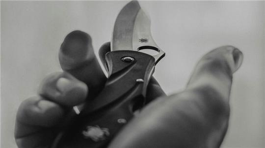 Eine Person hält ein Messer in der Hand.
