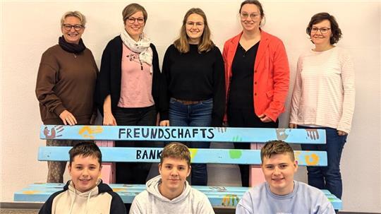 Geestlandschule: Ein farbenfrohes Zeichen der Freundschaft Schulleiterin Tanja Bovenschulte (von links) weiht mit Lehrkräften und den Schülern Thor Sturm (von links), Mika Till und Tom Tietjen die Bank ein.