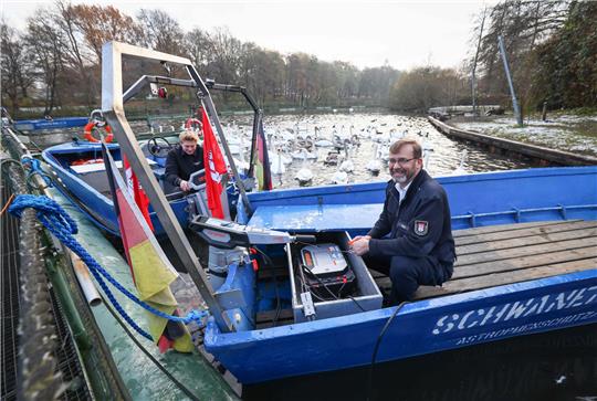 Schwanenvater Olaf Nieß (rechts) und sein Mitarbeiter Paul Lukas Lüken bereiten zwei mit E-Motoren umgebaute Boote für die Alsterschwäne vor. Foto: Christian Charisius/dpa