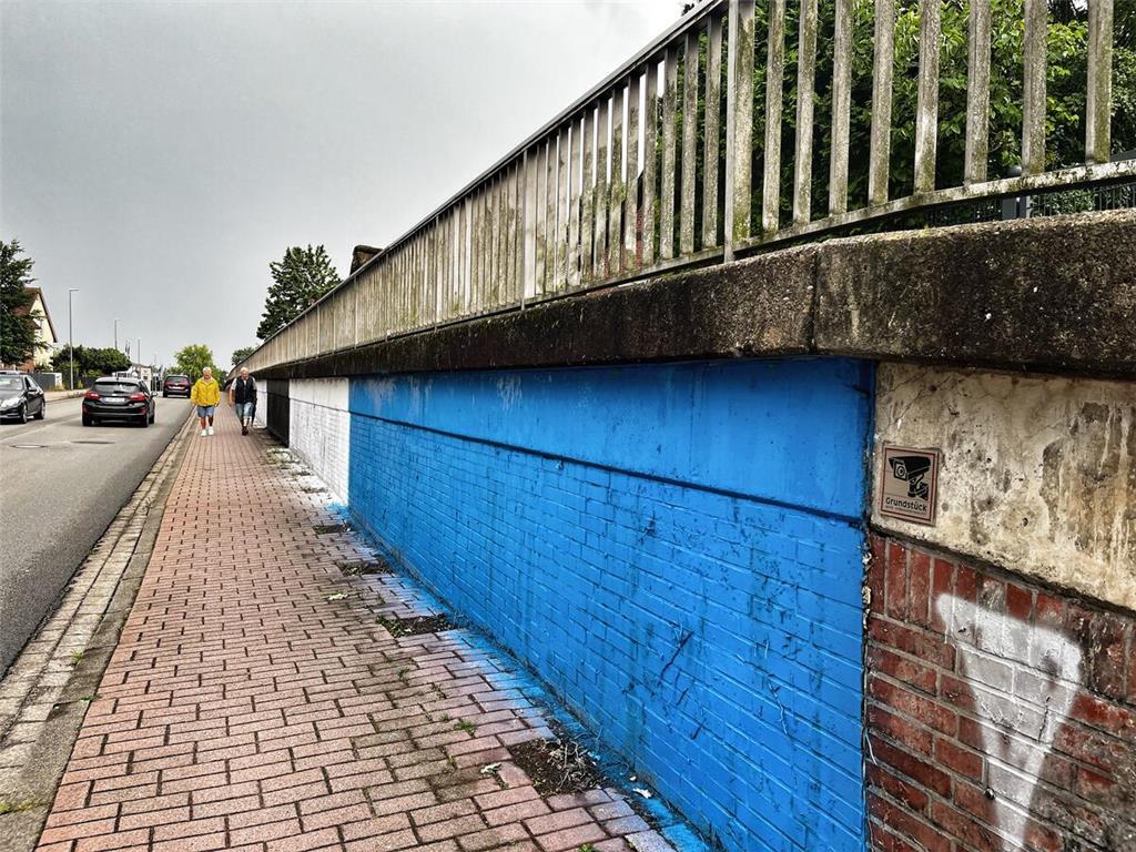 Schwarz-Weiß-Blau besprüht: Die Backsteinklinker-Spundwand an der Harburger Stra...