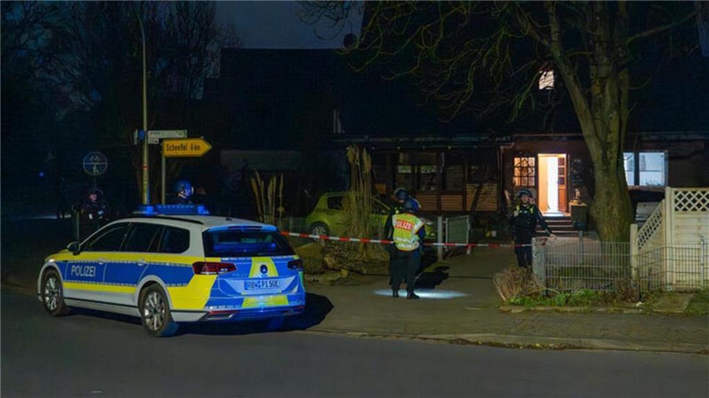 Schwerbewaffnete Polizisten stehen vor einem Wohnhaus in Scheeßel. Foto: JOTO