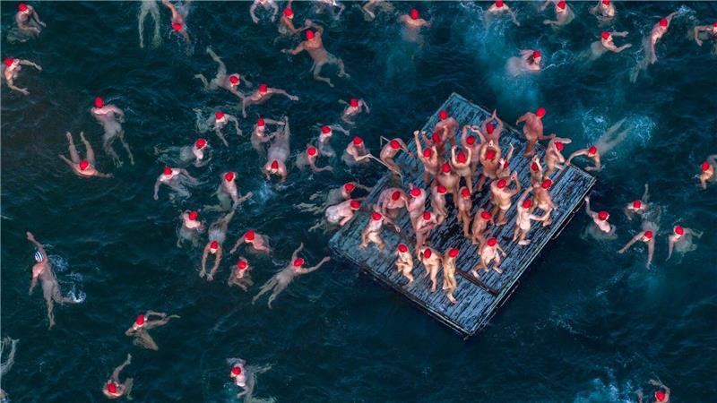 Schwimmer nehmen am jährlichen Nacktbad zur Wintersonnenwende im Rahmen des „Dark Mofo“-Festivals in Hobart am Long Beach teil.