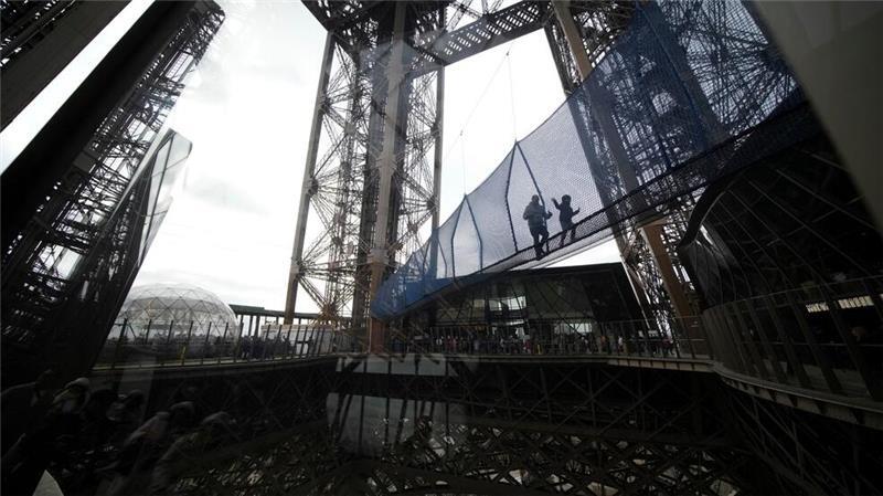 Schwindelerregend hoch: Besucher überqueren eine 40 Meter lange Brücke in rund 60 Metern Höhe, die mit Netzen ausgestattet ist und bis zum 9. März im ersten Stock des Eiffelturms aufgebaut ist.