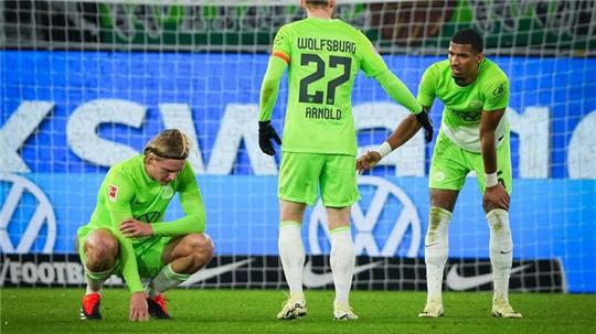 Sebastiaan Bornauw (l-r), Maximilian Arnold, und Cédric Zesiger von Wolfsburg zeigen sich nach dem Schlusspfiff enttäuscht.