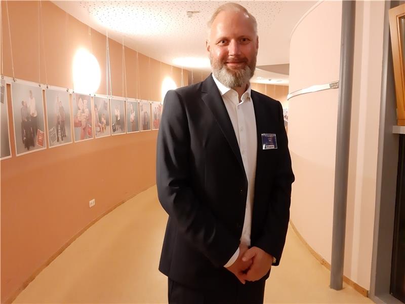 Sebastian Beck ist ab 1. Oktober neuer Geschäftsführer der Lebenshilfe Buxtehude. Im Hintergrund ist die Foto-Ausstellung anlässlich des 60-jährigen Bestehens der Lebenshilfe zu sehen. Foto: Frank