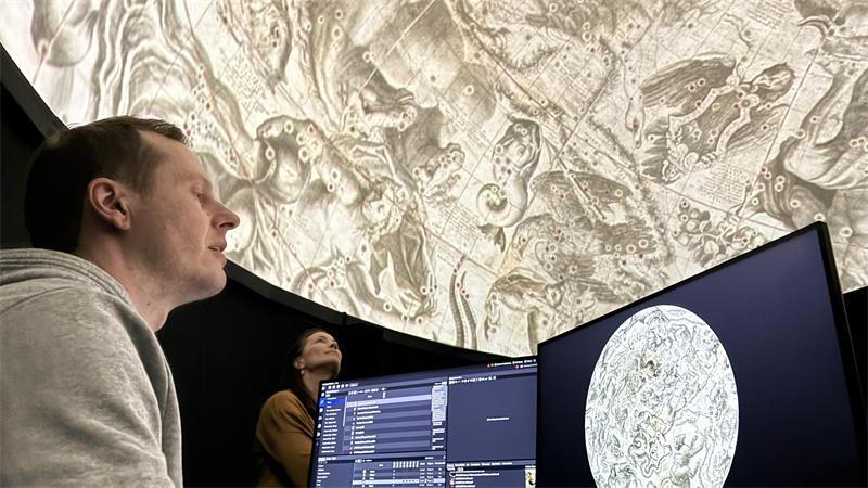 Sebastian Ipach und Christine Richards bestaunen die Projektionen im Planetarium.