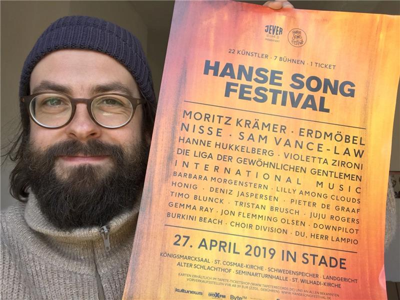 Sebastian Tim mit dem Plakat des Hanse Song Festivals.  Fotos Stade Marketing und Tourismus GmbH