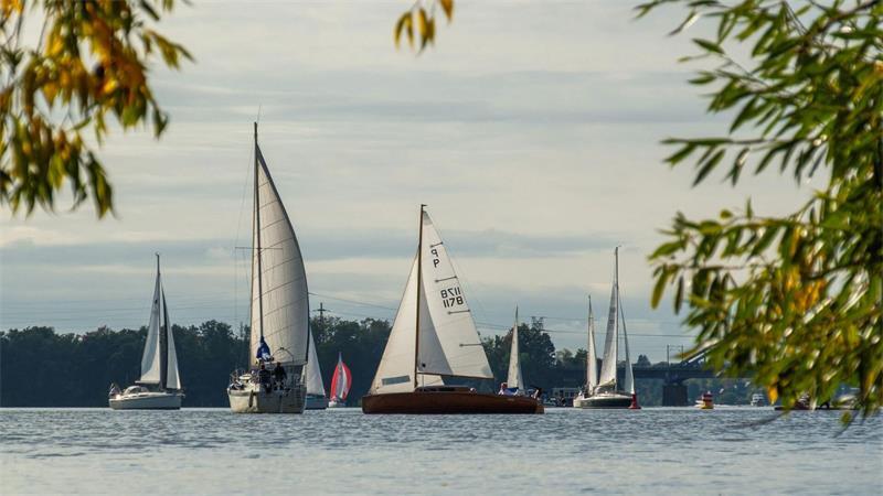 Segelboote sind bei herbstlichem Wetter auf dem Templiner See in Potsdam unterwegs.