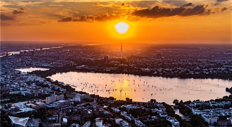Segler genießen in ihren Booten den Sonnenuntergang über der herbstlichen Außenalster. Foto: Elsen
