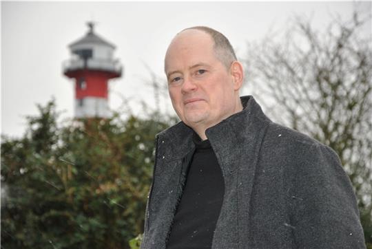 Sein Vorgarten liegt im Schatten des Leuchtturms: Graphic-Novel-Autor und -Zeichner Stephan Hagenow lebt in Grünendeich. Foto: Lohmann