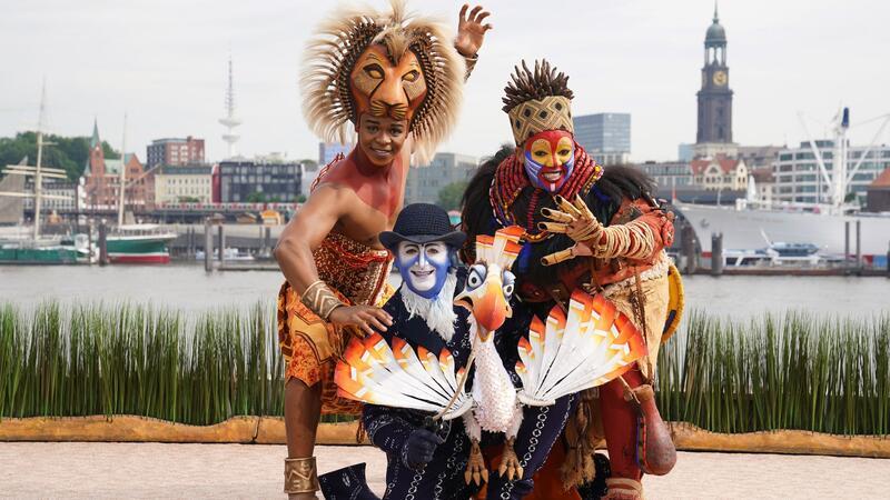 „König der Löwen“-Darsteller feiert Rekord-Jubiläum Seine Figur Zazu trägt Joachim Benoit (Mitte) auf der Bühne als Puppe auf der Hand. (Archivbild)