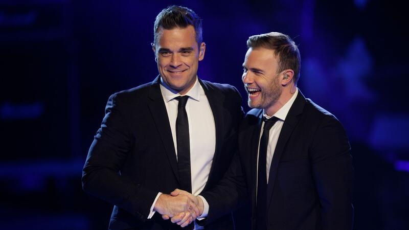 Take-That-Rebell und Familienvater: Robbie Williams wird 50 Seine verbalen Angriffe gegen seine Take-That-Kollegen, insbesondere Gary Barlow, sind Williams heute peinlich. Auf dem Foto treten die beiden Sänger in der Castingshow „Popstars - Girls Forever“ in Köln auf (Archivbild).