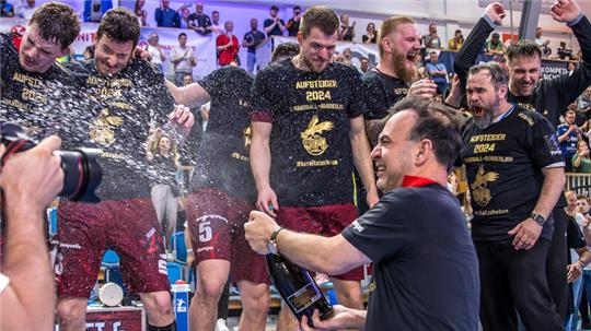 Sektdusche: Trainer Bob Hanning und Joshua Thiele (2. von links) feiern den Aufstieg.