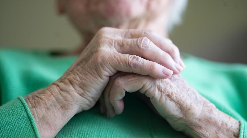 Resolute Seniorin verscheucht Trickdiebe aus ihrem Haus Eine Seniorin faltet ihre Hände.