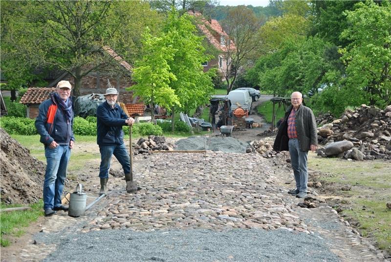 Sie beaufsichtigen die Pflasterarbeiten am Museumsdorf: Rainer Kröger mit Werner Heidenreich und Jürgen Kluit (von rechts). Foto: Lohmann
