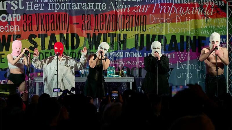 Sie sind immer noch wild und immer noch wütend. Beim Konzert der Band Pussy Riot gegen den Krieg in der Ukraine am Brandenburger Tor stehen Bandmitglieder mit Stoffmasken auf der Bühne.