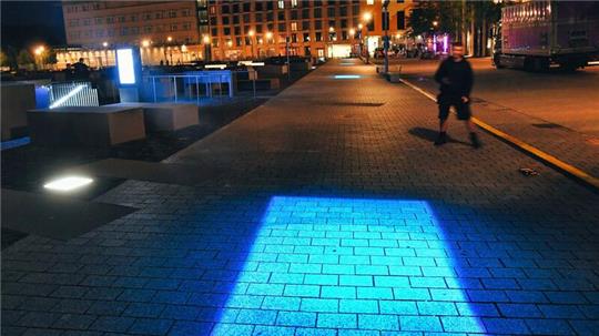 Sieben blaue Vierecke sind bei der Lichtaktion am Denkmal für die ermordeten Juden Europas zu sehen.
