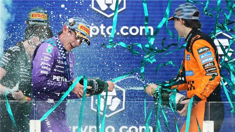 Sieger Mercedes-Pilot Kimi Antonelli (l) aus Italien feiert mit dem drittplatzierten McLaren-Fahrer Oscar Piastri aus Australien auf dem Podium nach dem Großen Preis von Miami.
