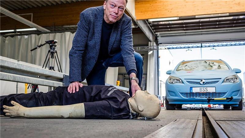 Siegfried Brockmann zeigt mit einer Puppe, was bei einem Unfall zwischen Fußgänger und Auto passieren kann.