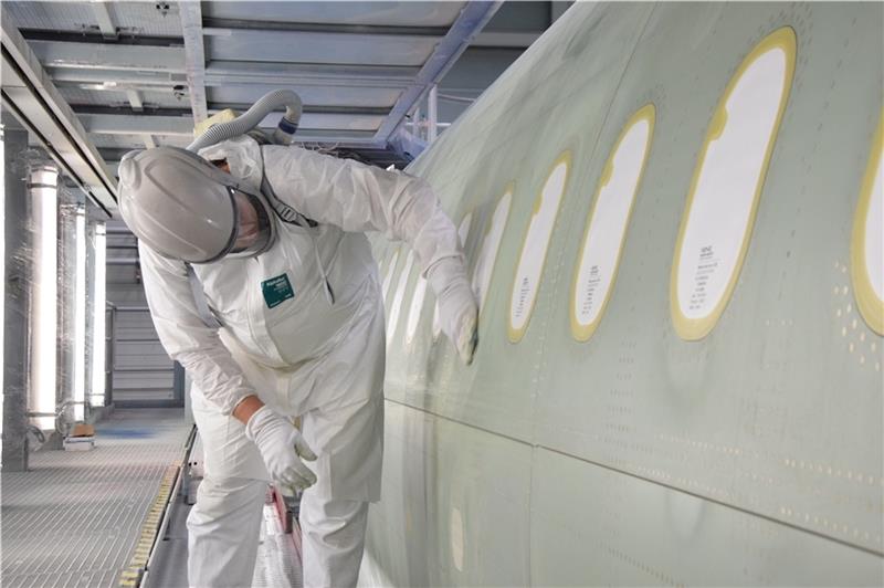 Sieht in voller Schutzkleidung ein bisschen wie ein Raumfahrer aus: Frank Beier, Aircraft-Painter bei Airbus, schleift den Rumpf eines A321 ab. Fotos: Battmer