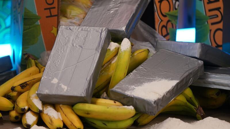 Silber-graue Pakete und weißes Pulver, das Kokain darstellen soll, liegt neben Bananen und Bananenkisten während der Vorstellung der Awareness-Kampagne für Hafenbeschäftigte im Kampf gegen internationale Drogenkriminalität.