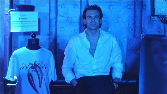 Simon Derks während seiner Graduationsshow auf der MS Stubnitz. Das T-Shirt links neben ihm hat Derks selbst designt. Der Erlös geht an ein soziales Projekt.