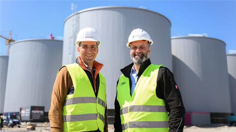 Biomethananlage im XXL-Format liefert Kraftstoff aus Mist und Gülle Simon Detscher (l), geschäftsführender Gesellschafter der revis bioenergy GmbH, und Jan-Hendrik Friedrichs, Operative Leitung der nordfuel-GmbH, stehen vor den Behältern einer sich im Bau befindenden riesigen Biogasanlage. Foto: Mohssen Assanimoghaddam/dpa