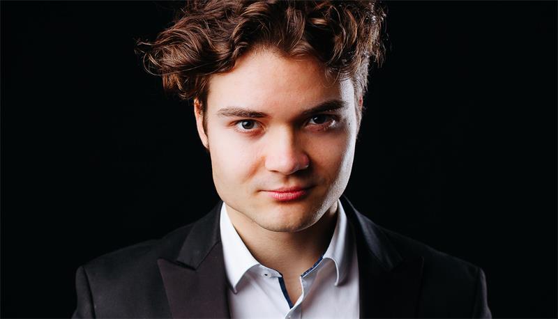 Meister am Piano: Konzerterlebnis auf Stackmanns Bühne in Buxtehude Porträt Simonas Poška, der mit einem verwegenen Blick in die Kamera schaut