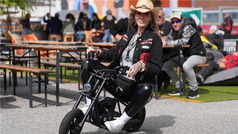 Sina vom Modelabel „Men of Mayhem“ fährt auf einem Mini-Chopper über das Veranstaltungsgelände auf dem Großmarkt Hamburg während des ersten Tages der Harley Days.
