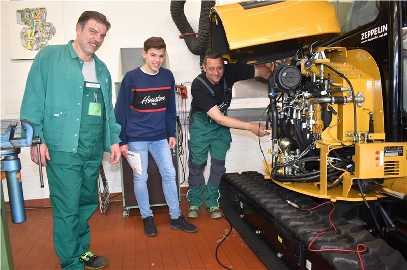 Sjard Heitmann (15) lässt sich von Obermeister Peter Brockmann (rechts) und Lehrlingswart Andreas Pape von der Innung für Land- und Baumaschinentechnik den Motor erklären. Fotos Vasel