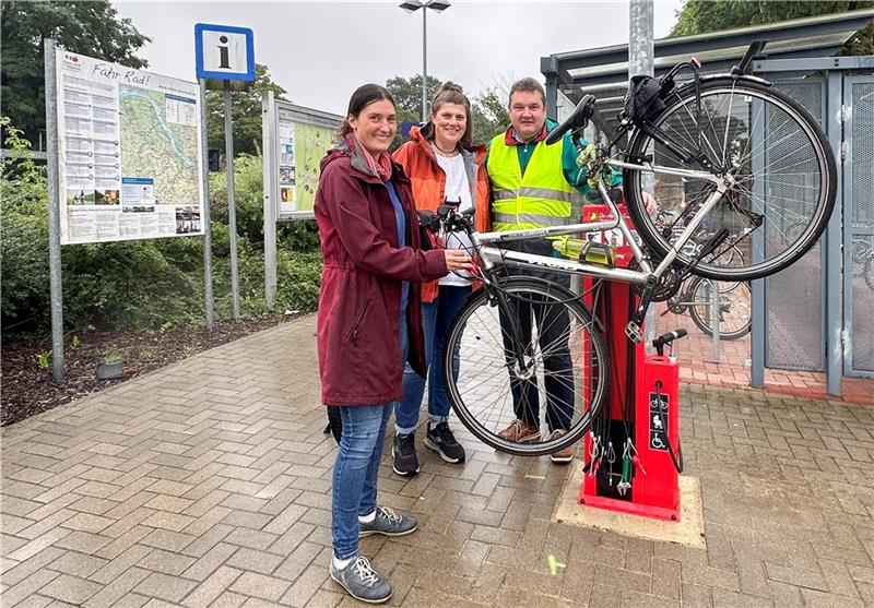 Diese roten Stelen sollten Fahrradfahrer in Himmelpforten kennen So funktioniert die Aufhängung an der Fahrrad-Reparaturstation, zeigen (von links) Klimaschutzmanagerin Britta Schieblon, Martina Wagner vom Standortmarketing der Samtgemeinde und Samtgemeindebürgermeister Holger Falke. Fotos: Dammer