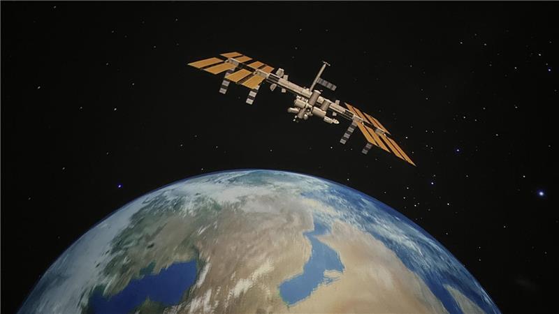 So sehen Besucher die Erde und eine Raumstation im Planetarium.