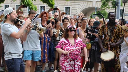 Künstlerin Marinella Senatore umgeben von Musikern und Schaulustigen bei einer ihrer öffentlichen Aktionen in München