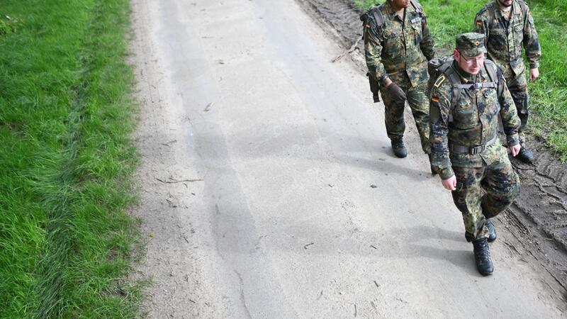 Soldaten der Bundeswehr gehen einen Waldweg entlang, nachdem sie ein Waldstück abgesucht haben.