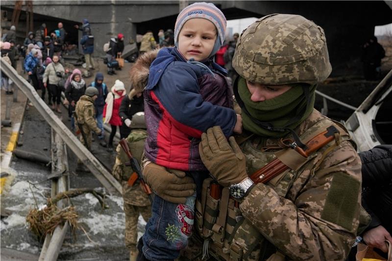 Soldaten der ukrainischen Armee helfen Menschen westlich von Kiew bei der Flucht. Foto: Vadim Ghirda/AP/dpa