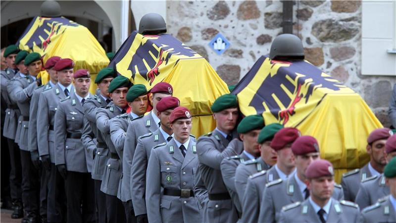 Soldaten tragen am 9. April 2010 nach der Trauerfeier für die drei in Afghanistan gefallenen Kameraden die Särge aus der St.- Lamberti-Kirche in Selsingen.