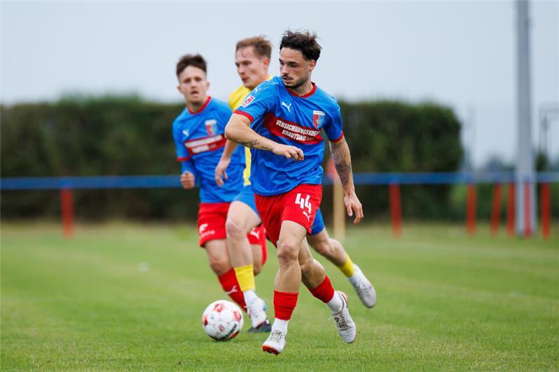 Robin Kölle im blauen Trikot und roter Hose erobert den Ball.