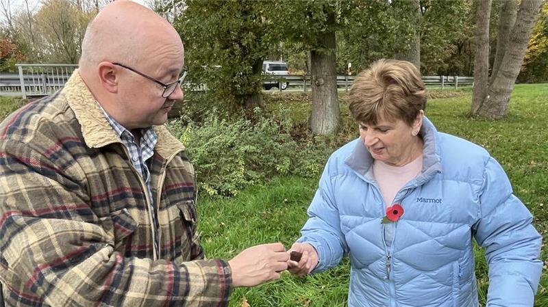 Sondengänger Frank Hoferichter überreicht Rose Askew die Reste des Panzers.