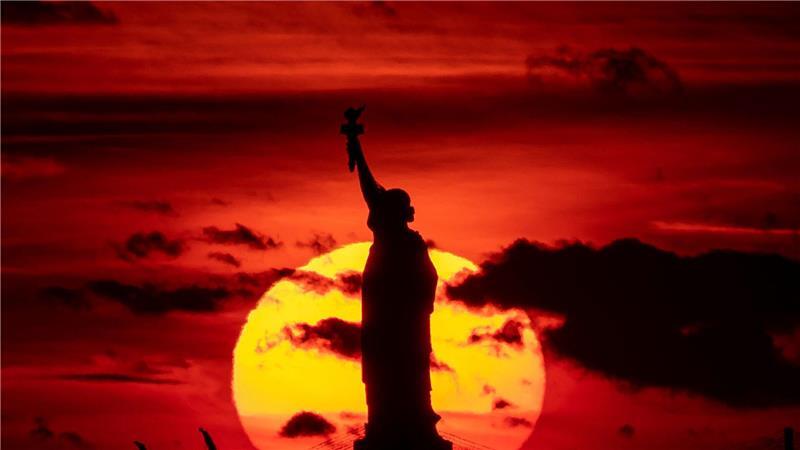 In Zeiten von Trump: Bleiben USA Traumziel für Deutsche? Sonnenuntergang hinter der Freiheitsstatue. (Archivbild)