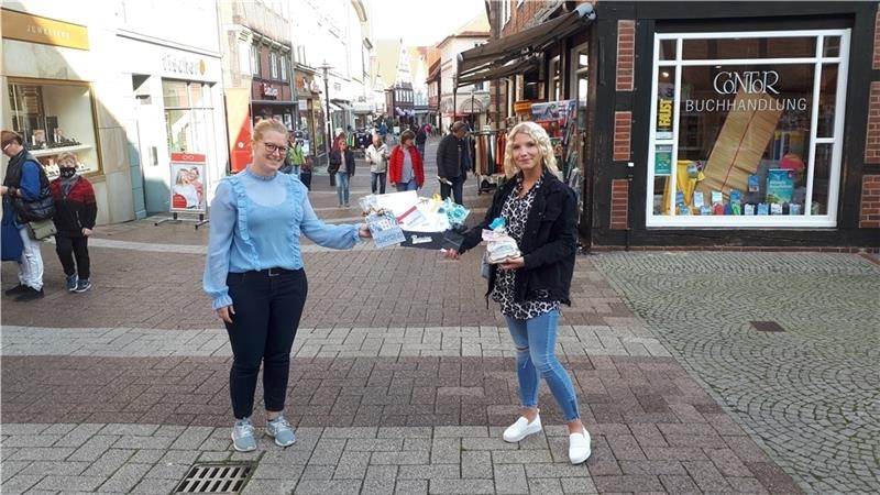Sophie Hohmeister von der Stade Marketing Tourismus GmbH (links) überreicht Heimatshopperin Johanna Krämer ihren Gewinn.