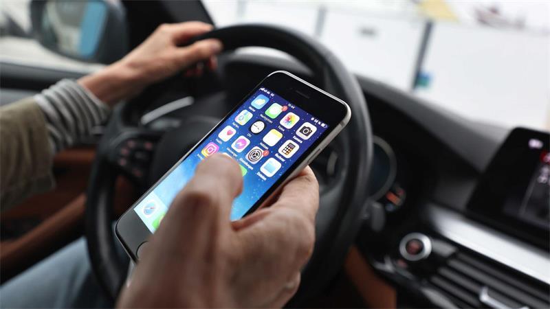 Sorgt für Ablenkung beim Fahren und dadurch immer wieder für Unfälle: das Smartphone am Steuer. (Illustration)