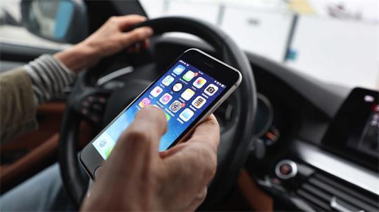 Sorgt für Ablenkung beim Fahren und dadurch immer wieder für Unfälle: das Smartphone am Steuer. (Illustration)