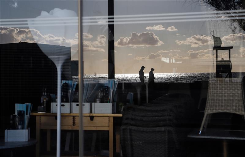 Spanien, Palma: Menschen spiegeln sich im August 2020 im Fenster einer geschlossenen Bar in der Schinkenstraße. Wegen stark steigender Corona-Infektionszahlen stuft die Bundesregierung ganz Spanien und damit auch Mallorca sowie die Kanaren am Sonntag erneut als Risikogebiet ein. Das gab das Robert Koch-Institut am Freitag bekannt. Foto: Clara Margais/dpa