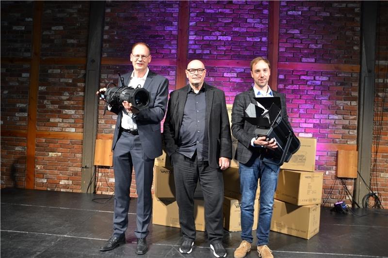 Sparkassenvorstand Wolfgang Schult (links) und NDB-Geschäftsführer Matthias Geier (rechts) unterstützen Seminarturnhallen-Leiter Peter Kühn bei der energetischen Umstellung der Bühnenbeleuchtung.