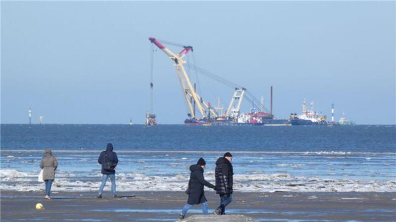 Blick auf den Döser Strand mit Wrack-Bergung im Hintergrund. 
