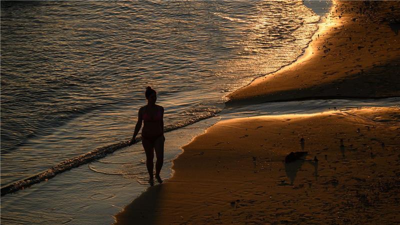 Spaziergang in der Abendsonne: Eine Person geht über den Sand am Milk Beach.