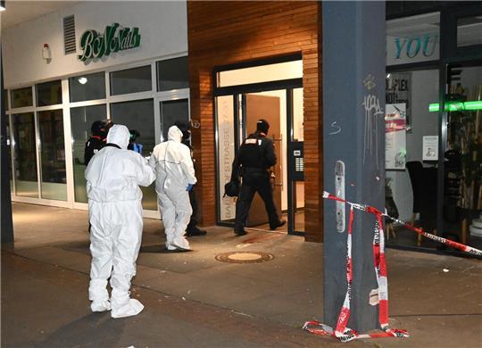 Spezialisten der Spurensicherung betreten das Wohn- und Geschäftshaus in der Bahnhofstraße 27-31.