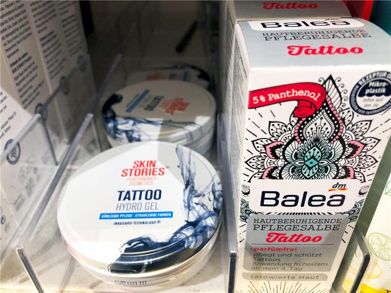 Spezielle Hautpflegeprodukte für Tätowierte stehen im Regal eines Drogeriemarktes. Foto: Gregor Tholl/dpa-Zentralbild/dpa
