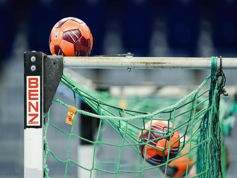 Spielbälle liegen im Netz eines Handball-Tors. Foto: Uwe Anspach/dpa/Symbolbild