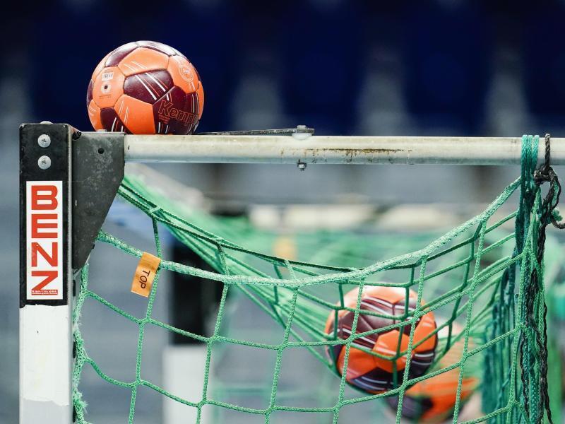 Spielbälle liegen im Netz eines Handball-Tors. Foto: Uwe Anspach/dpa/Symbolbild